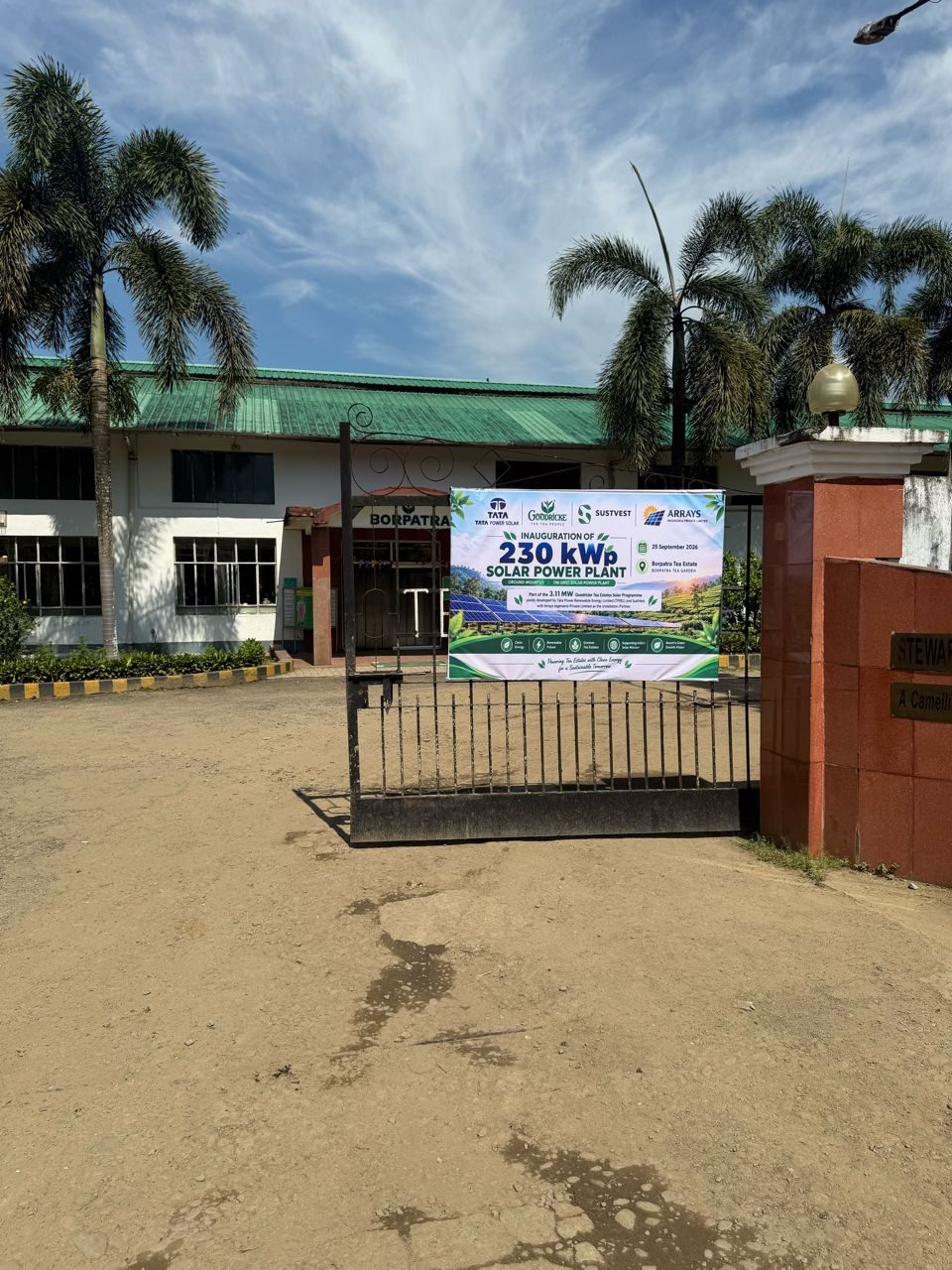 Borpatra Tea Estate gate with the banner for the inauguration of the 230 kWp ground-mounted on-grid solar power plant, 25 September 2026, Tata Power Solar, Goodricke, Sustvest and Arrays Ingenieria